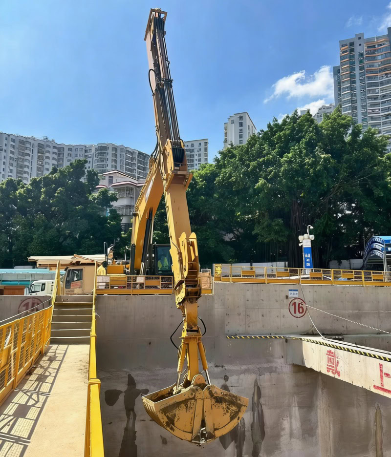 The XCMG excavator is equipped with a telescopic arm and a clamshell bucket.
